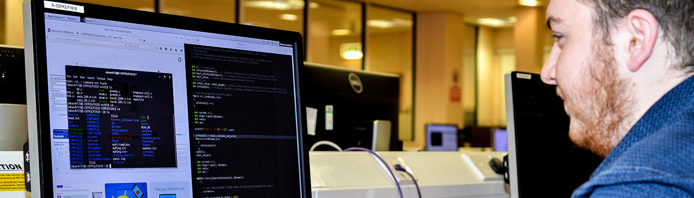 Student looking at code on a computer monitor