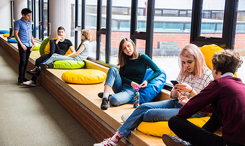 Group of students lounging on cushions in Kilburn Building