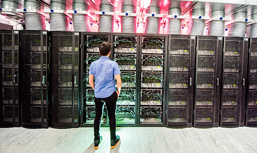 A male student standing in front of the Human Brain computer