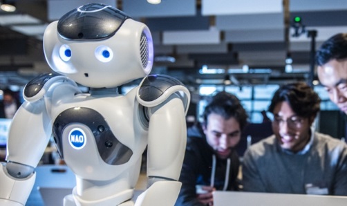 AI robot with students at a laptop in the background