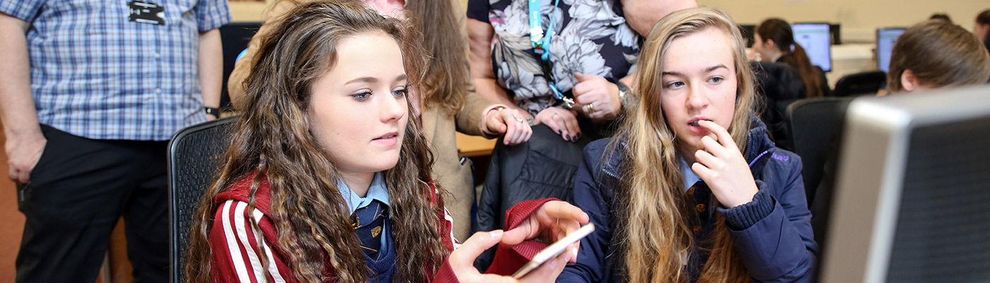 Schoolchildren working with their mobile phones and a computer