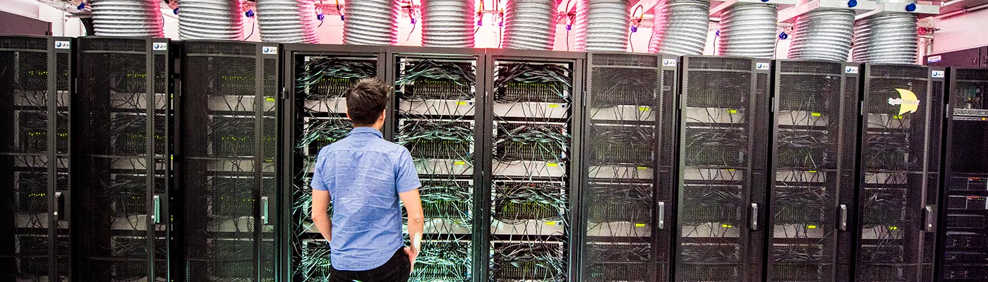 A male student standing in front of the Human Brain computer