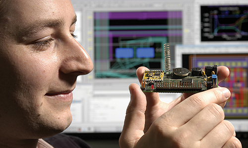 Doctoral training student inspecting a circuit board at close quarters